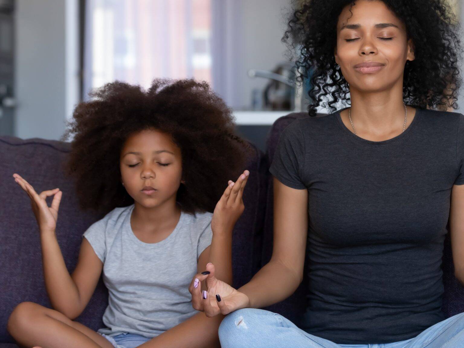 Cardiovascular Health - Mother and daughter meditating together on a couch, embodying a serene approach to lowering stress and managing blood pressure naturally with meditation techniques.