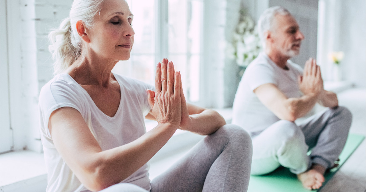 Group of ladies indoors engaged in deep breathing exercises, focusing on techniques to promote calmness and mental well-being.