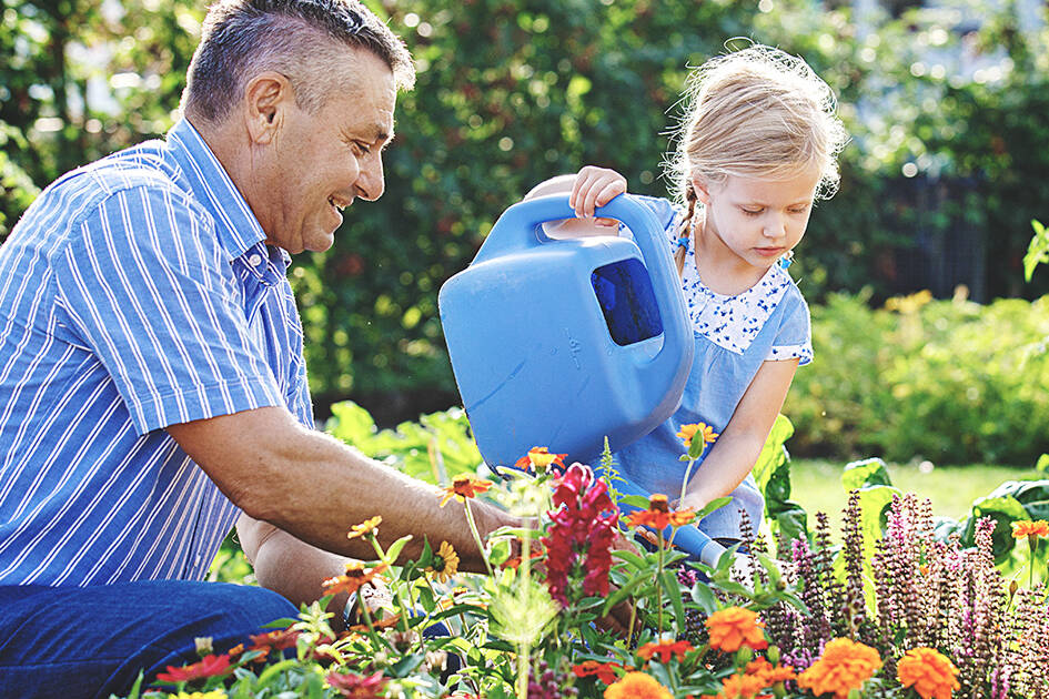 Heart Health Supplement - A father and daughter watering plants together outdoors, symbolizing healthy lifestyle choices.