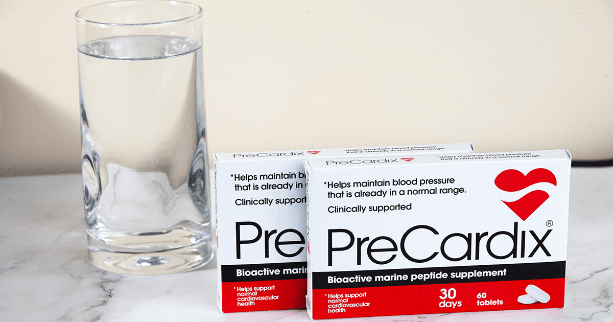 Heart Hydration: A PreCardix® package box next to a clear glass of water, placed on a marble table indoors.
