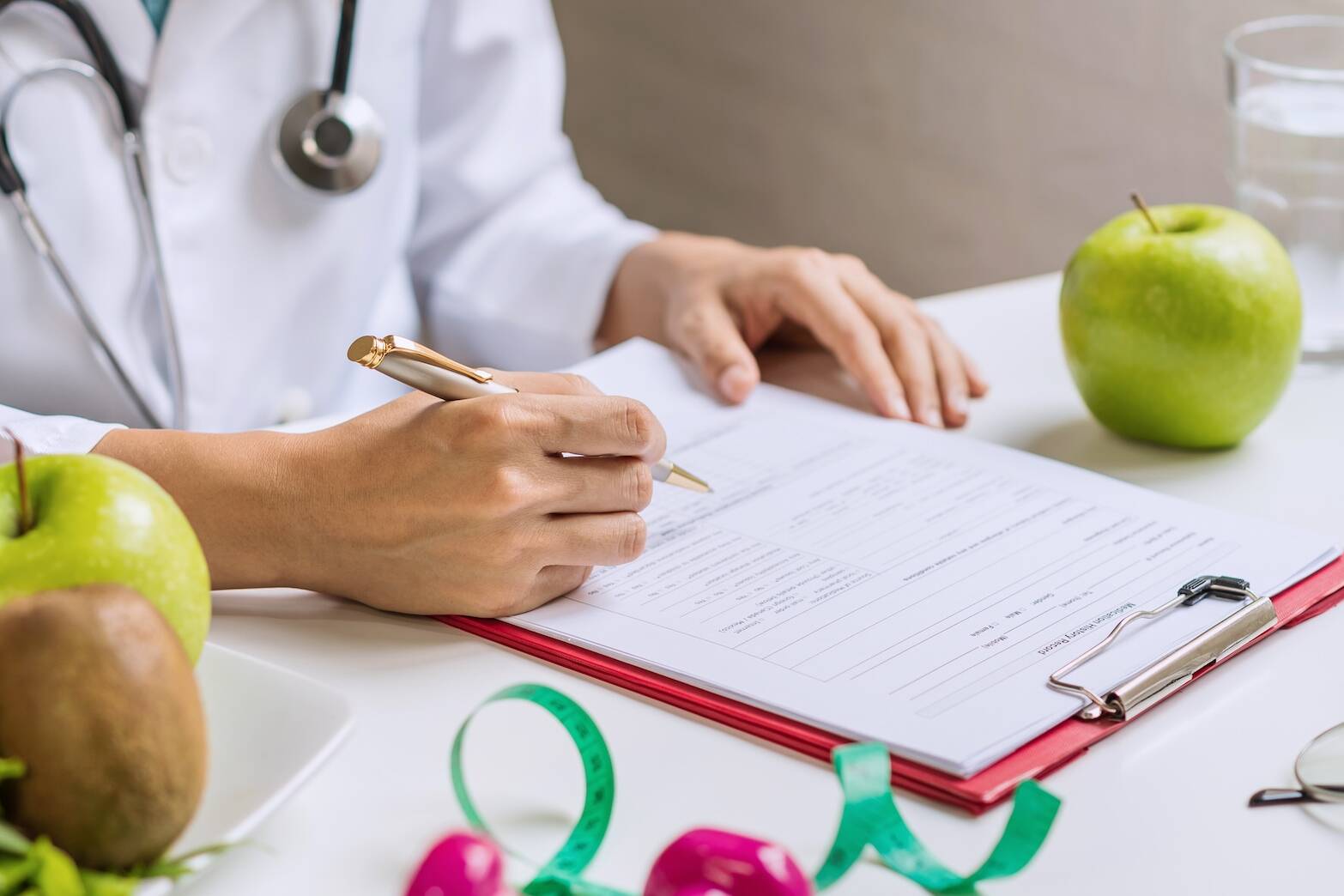 Nutritionist consulting patient on heart health with fruits and vegetables on table