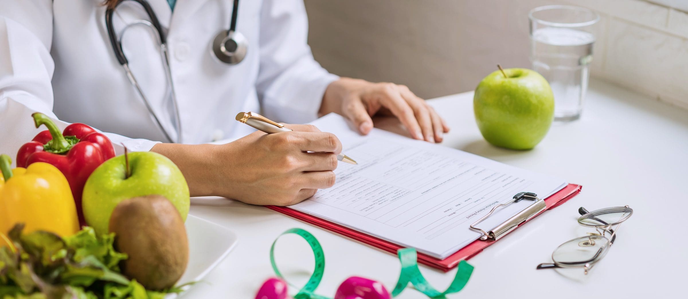Nutritionist consulting patient on heart health with fruits and vegetables on table