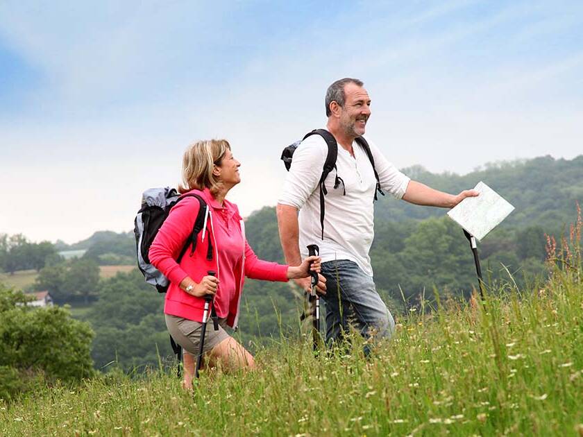 cardiovascular wellness - Happy couple walking in the park, smiling and looking well-rested on a sunny day.