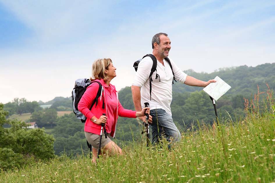 cardiovascular wellness - Happy couple walking in the park, smiling and looking well-rested on a sunny day.